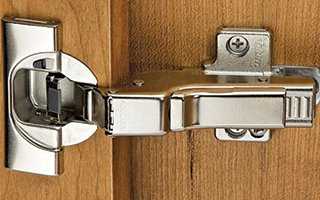 What is the process for drilling pilot holes for cabinet hinges?